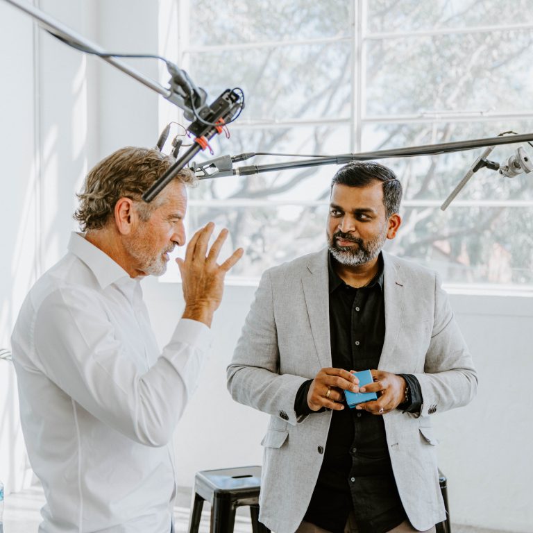 Light & Glo co-founder presenting premium scented product packaging to a business partner during a studio recording session, showcasing Australian innovation and brand storytelling.
