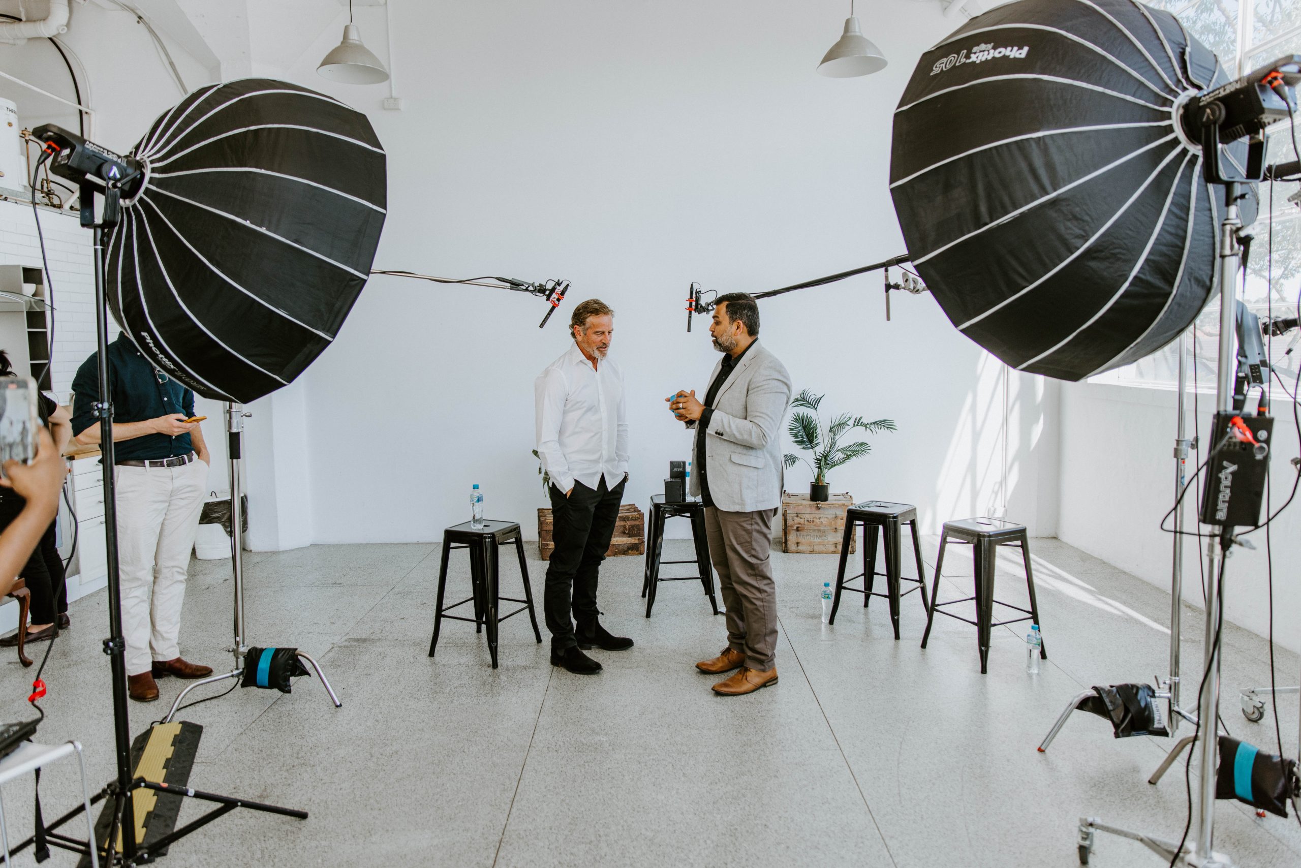 Light & Glo co-founder presenting premium scented product packaging to a business partner during a studio recording session, showcasing Australian innovation and brand storytelling.